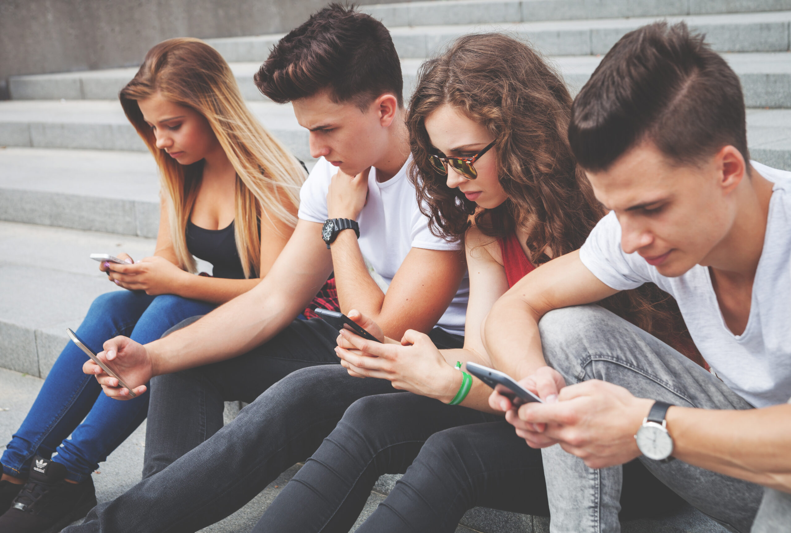 Group of friends sitting together using their phones group of friends sitting together using their phon 2024 10 31 04 28 54 utc scaled