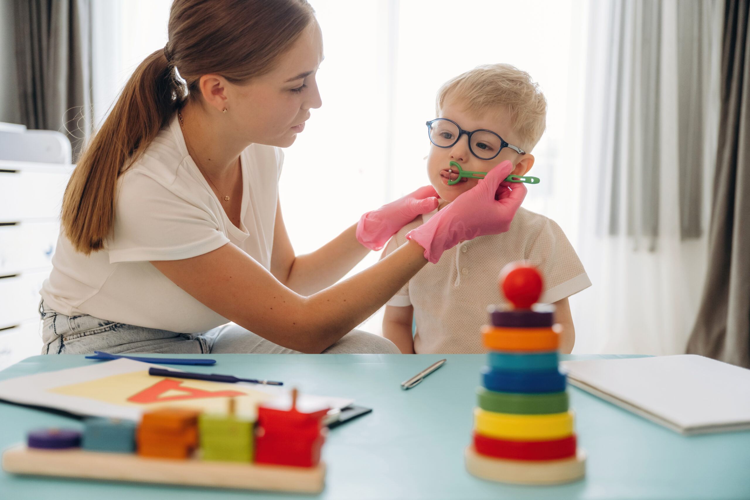 Exercises, using special device on tongue. Speech therapist is with young boy indoors exercises using special device on tongue speech 2026 03 25 23 56 11 utc scaled